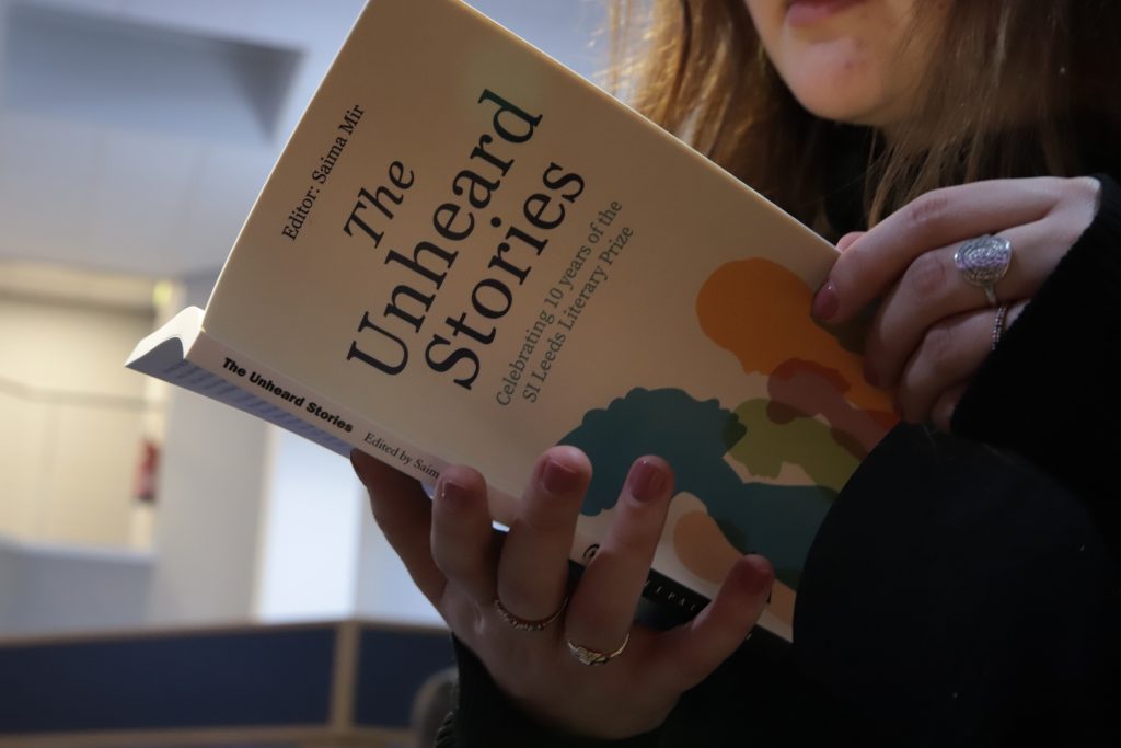 A woman reading The Unheard Stories anthology